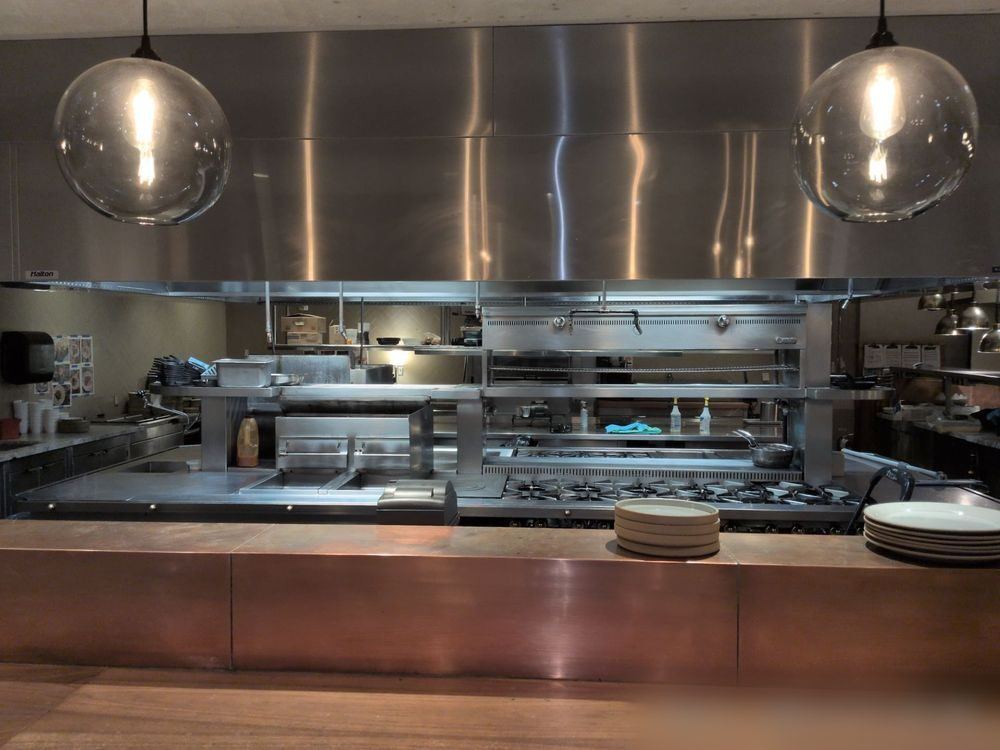 Finished commercial kitchen with a clean stainless steel hood